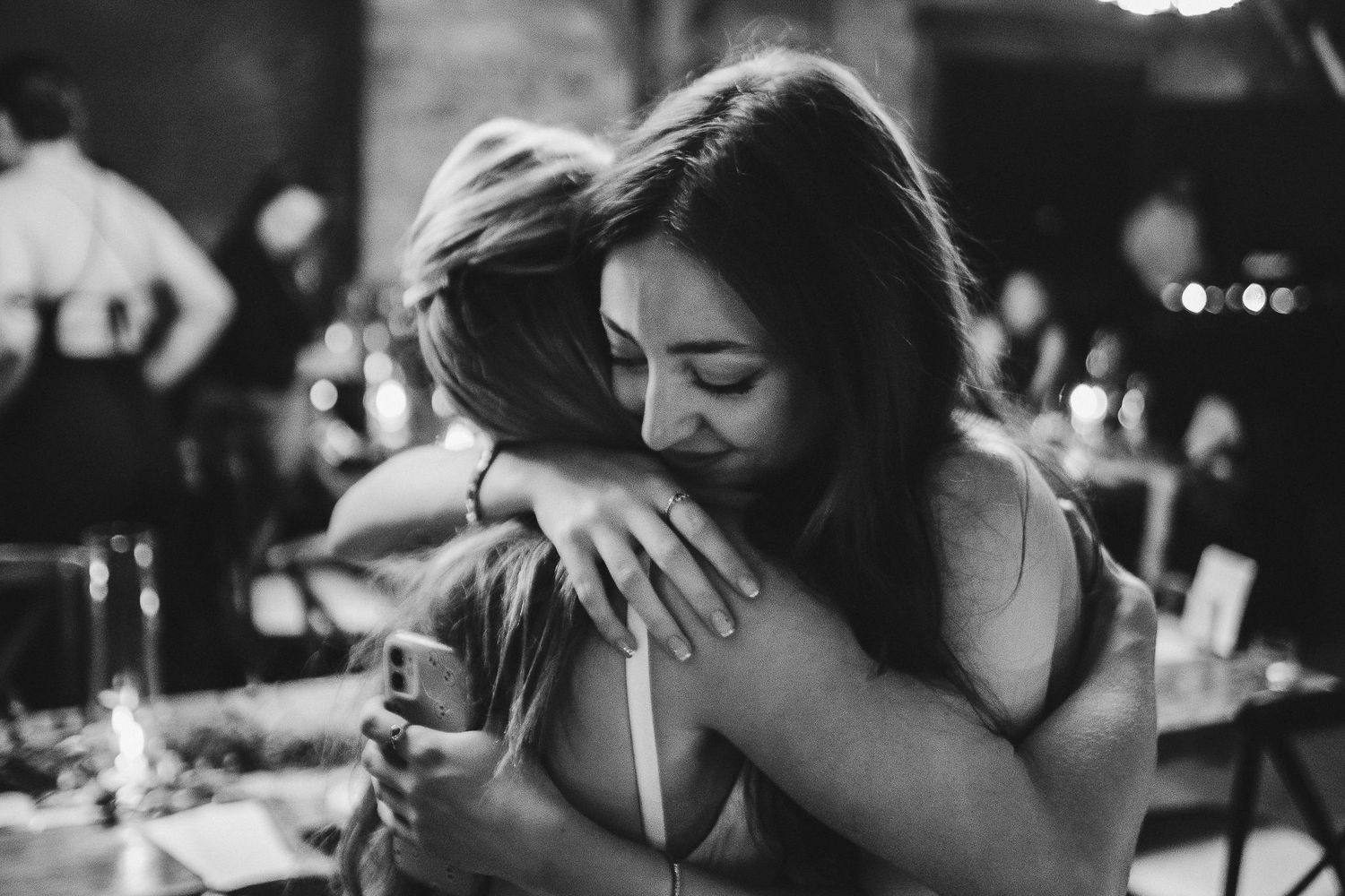 Black and white emotional embrace captured during an intimate celebration moment.