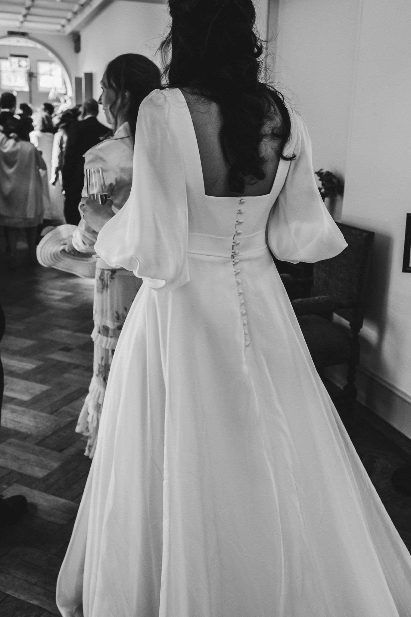 Back view of elegant wedding dress with button details and billowing sleeves.