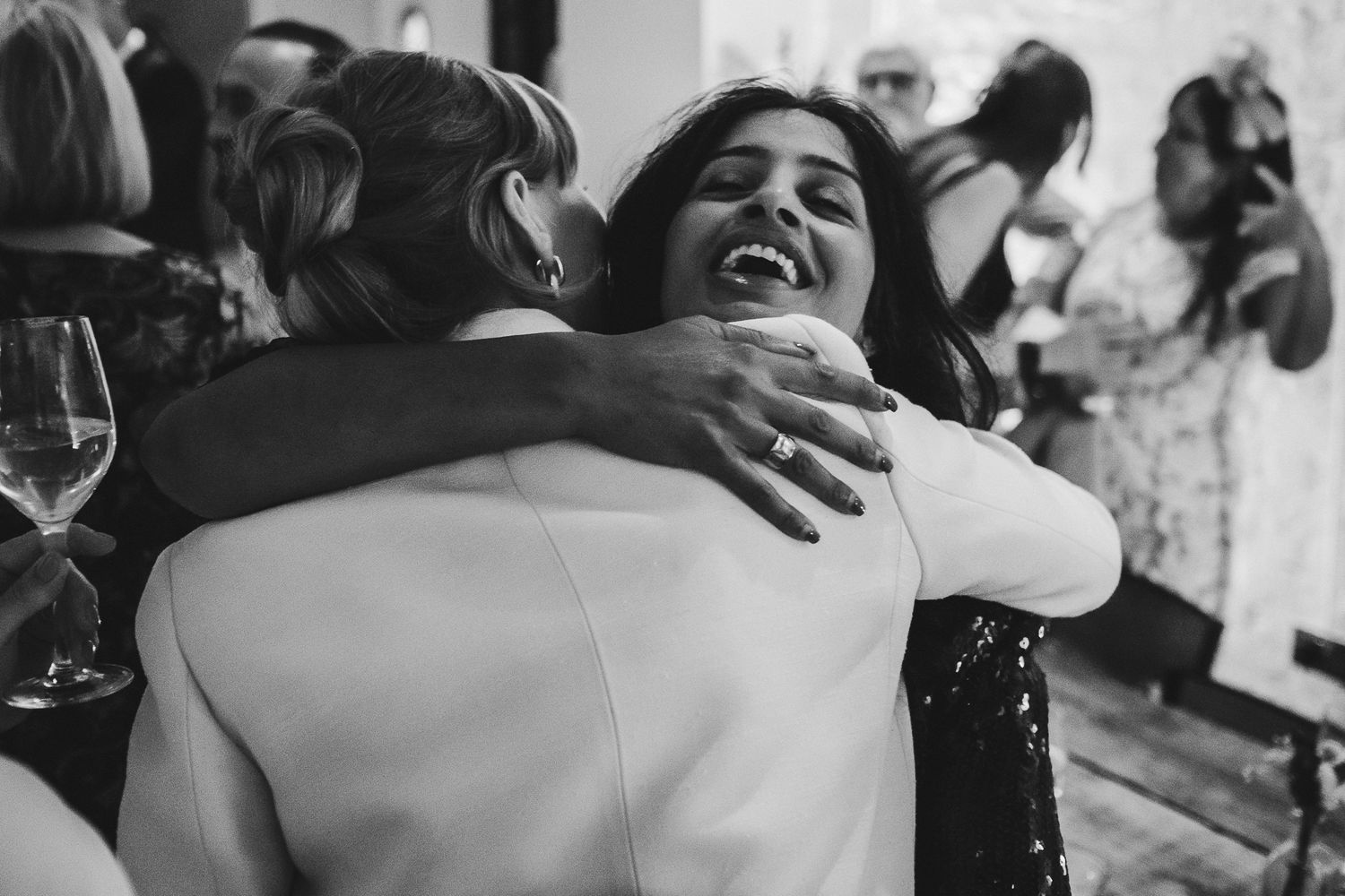Wedding guests embrace and celebrate during the reception festivities.
