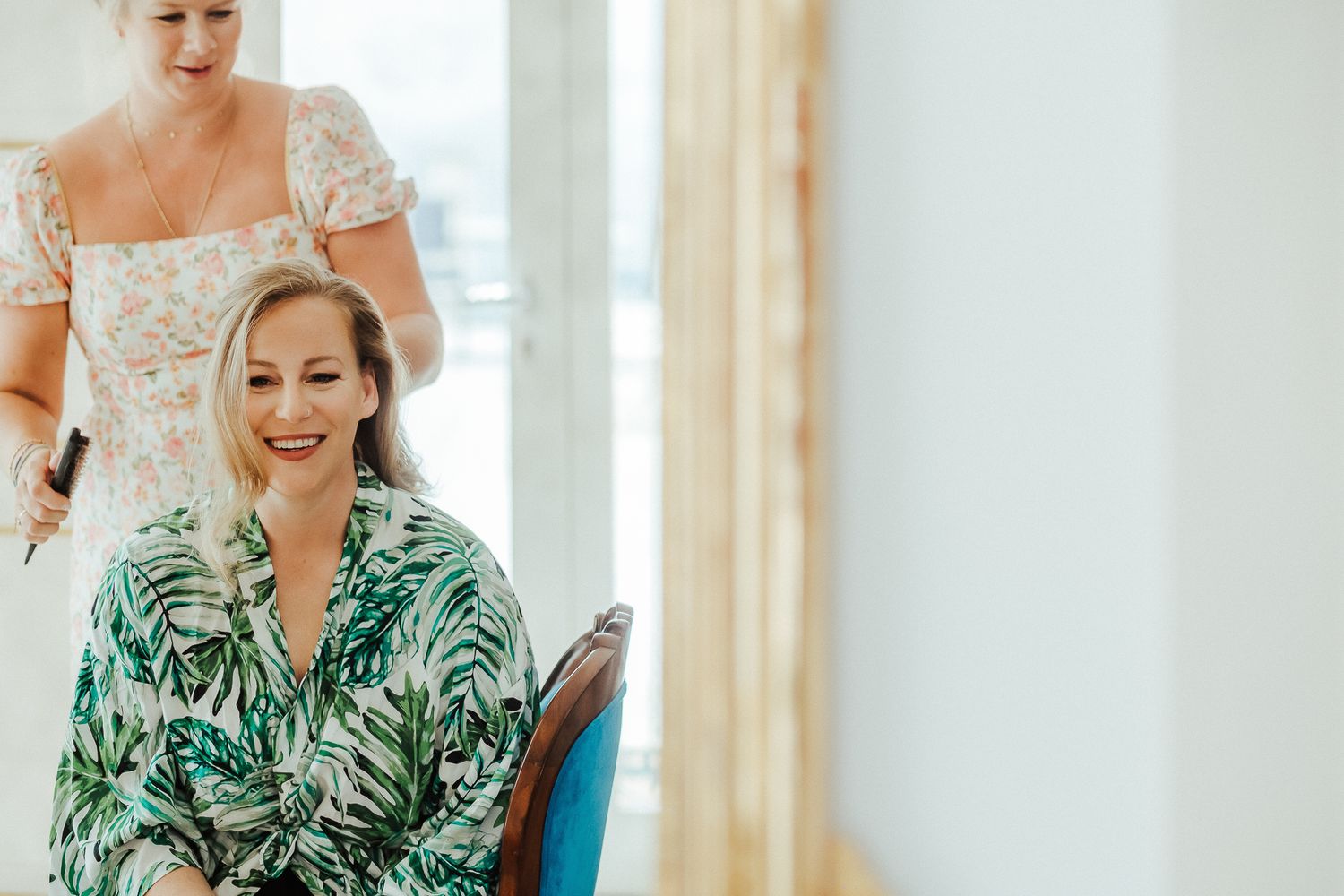 Wedding preparations featuring a mix of formal and floral dresses in a sunlit room.