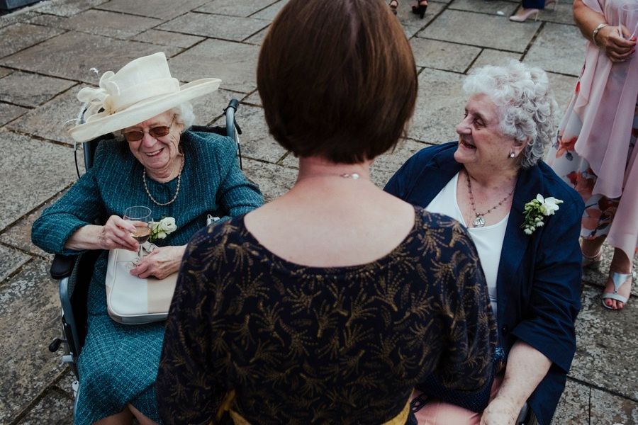 Wedding guests enjoying conversation at an outdoor reception.