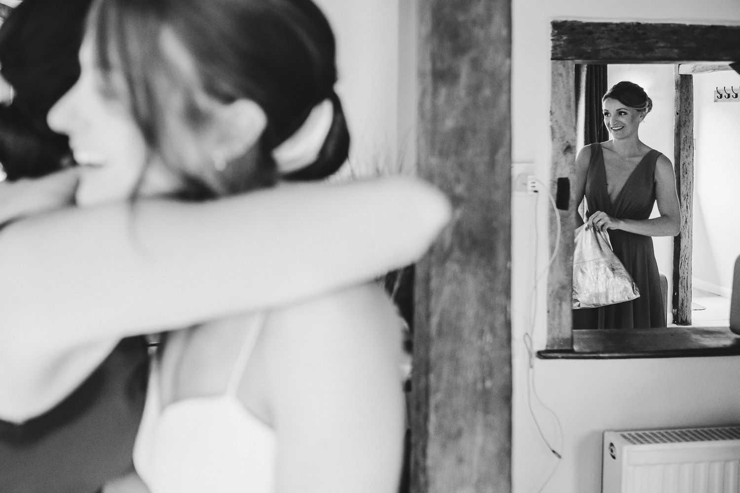 Black and white wedding preparation photo with reflections in a mirror.