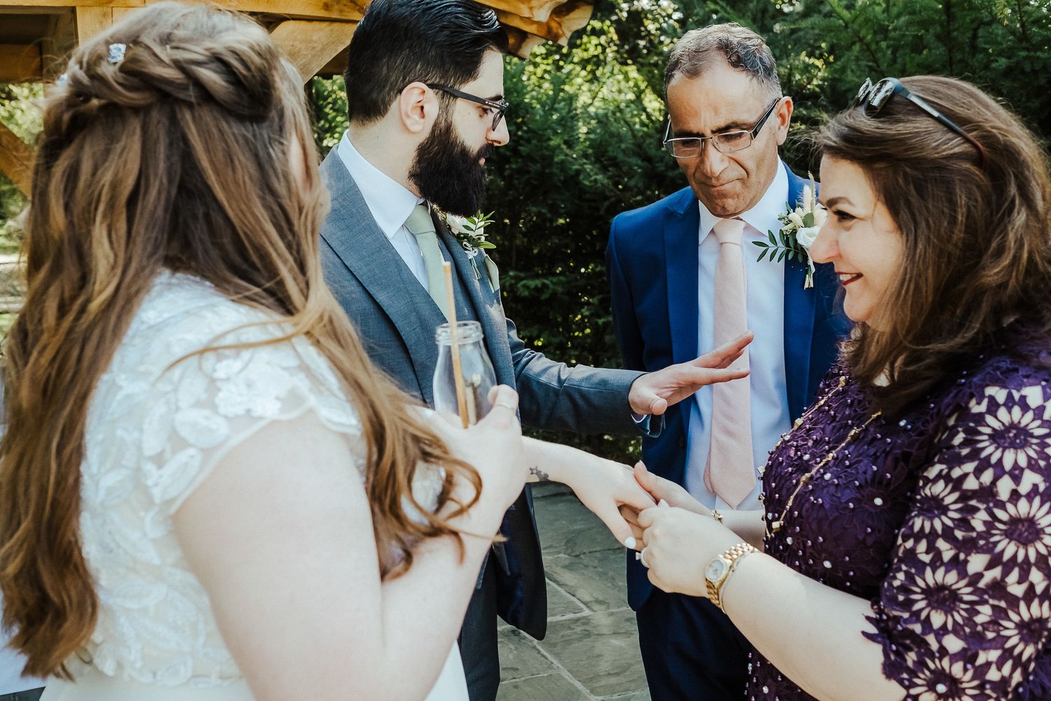Wedding guests gather outdoors for casual conversation during a summer garden reception.