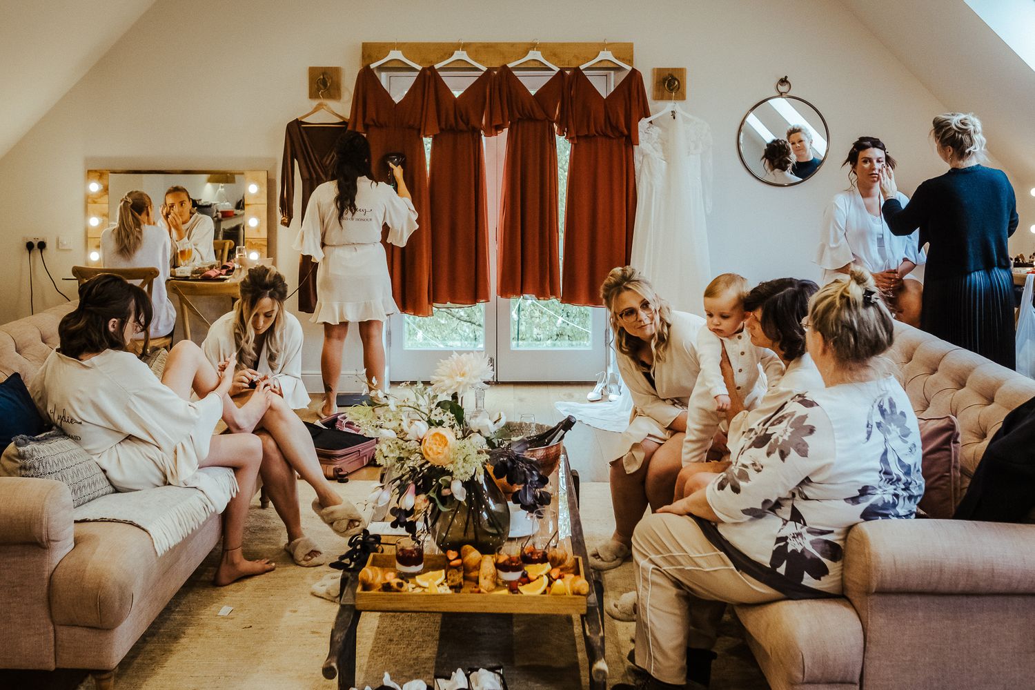 Wedding guests gather in a cozy living room for pre-ceremony preparations.