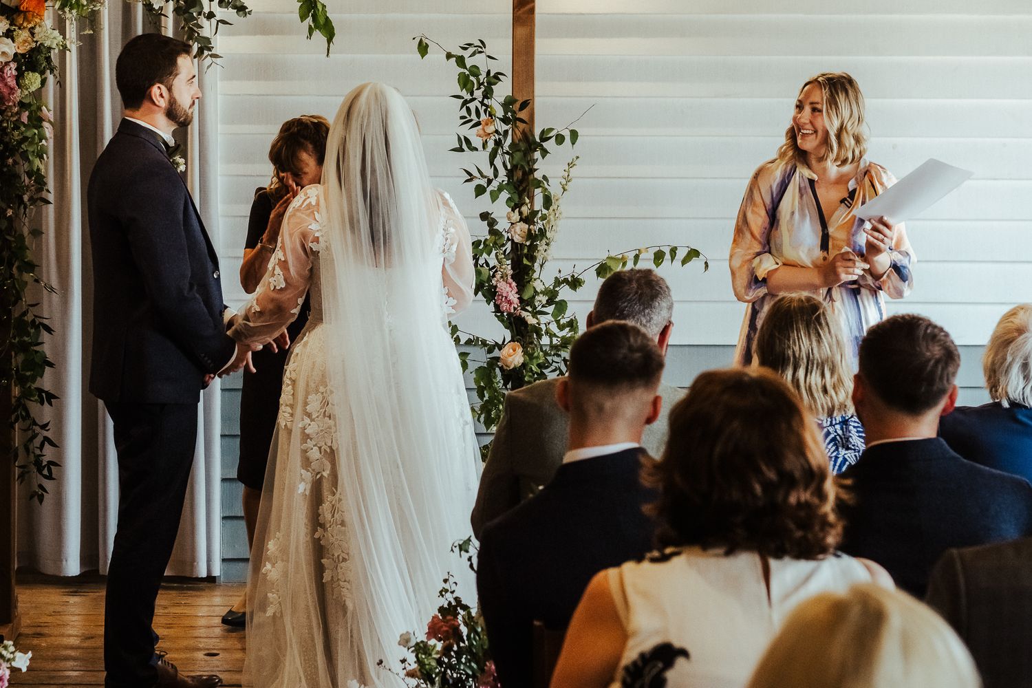 Wedding ceremony in progress with guests seated watching the couple at the altar.