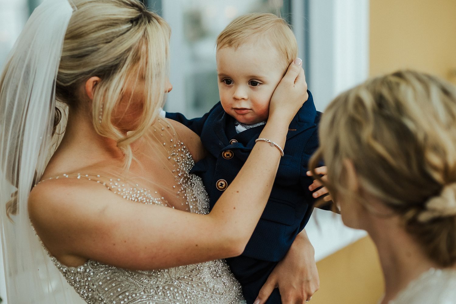 Tender moment with a young child during wedding preparations.