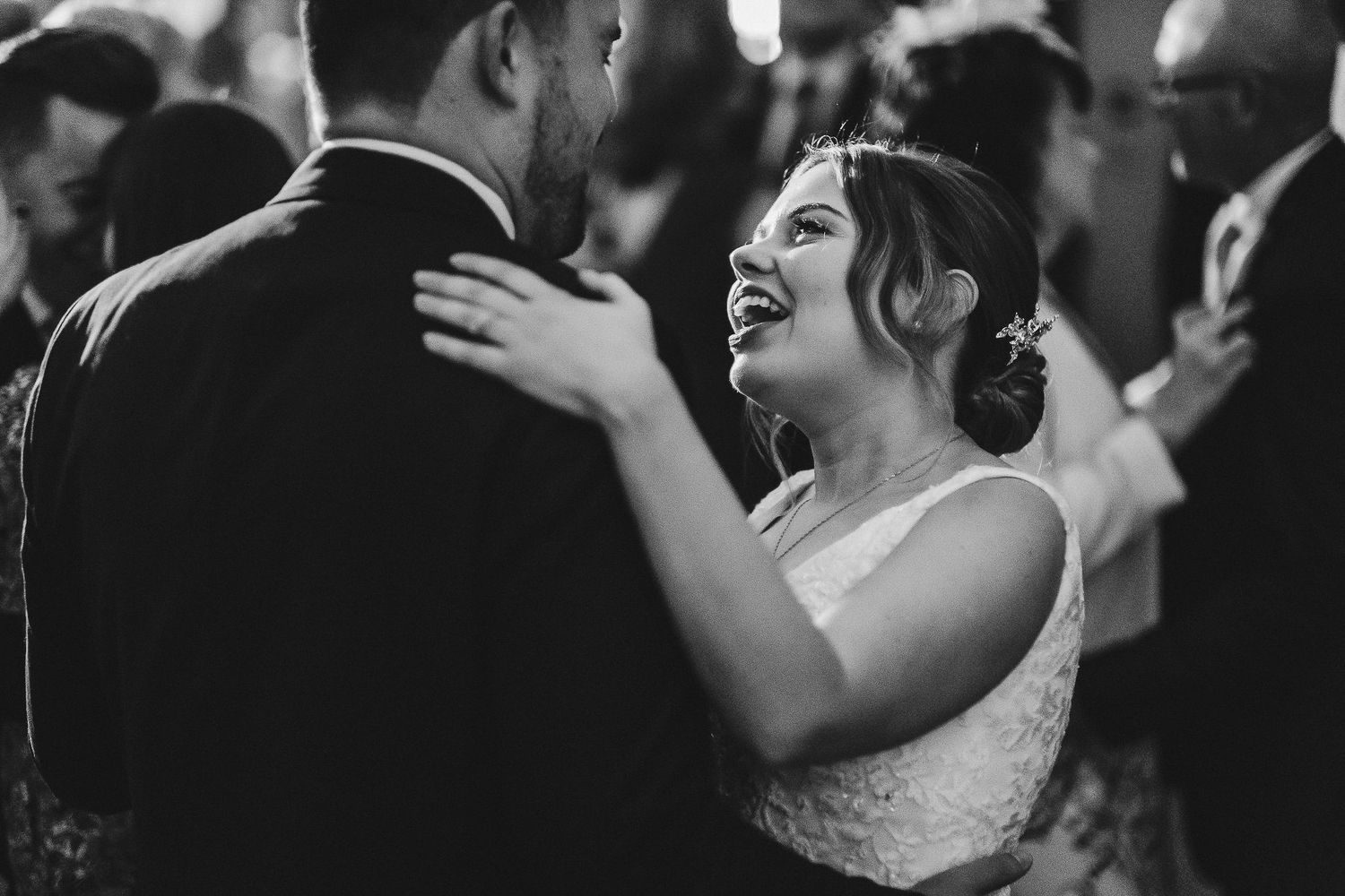 A romantic black and white capture of a couple sharing an intimate dance moment at their wedding reception.