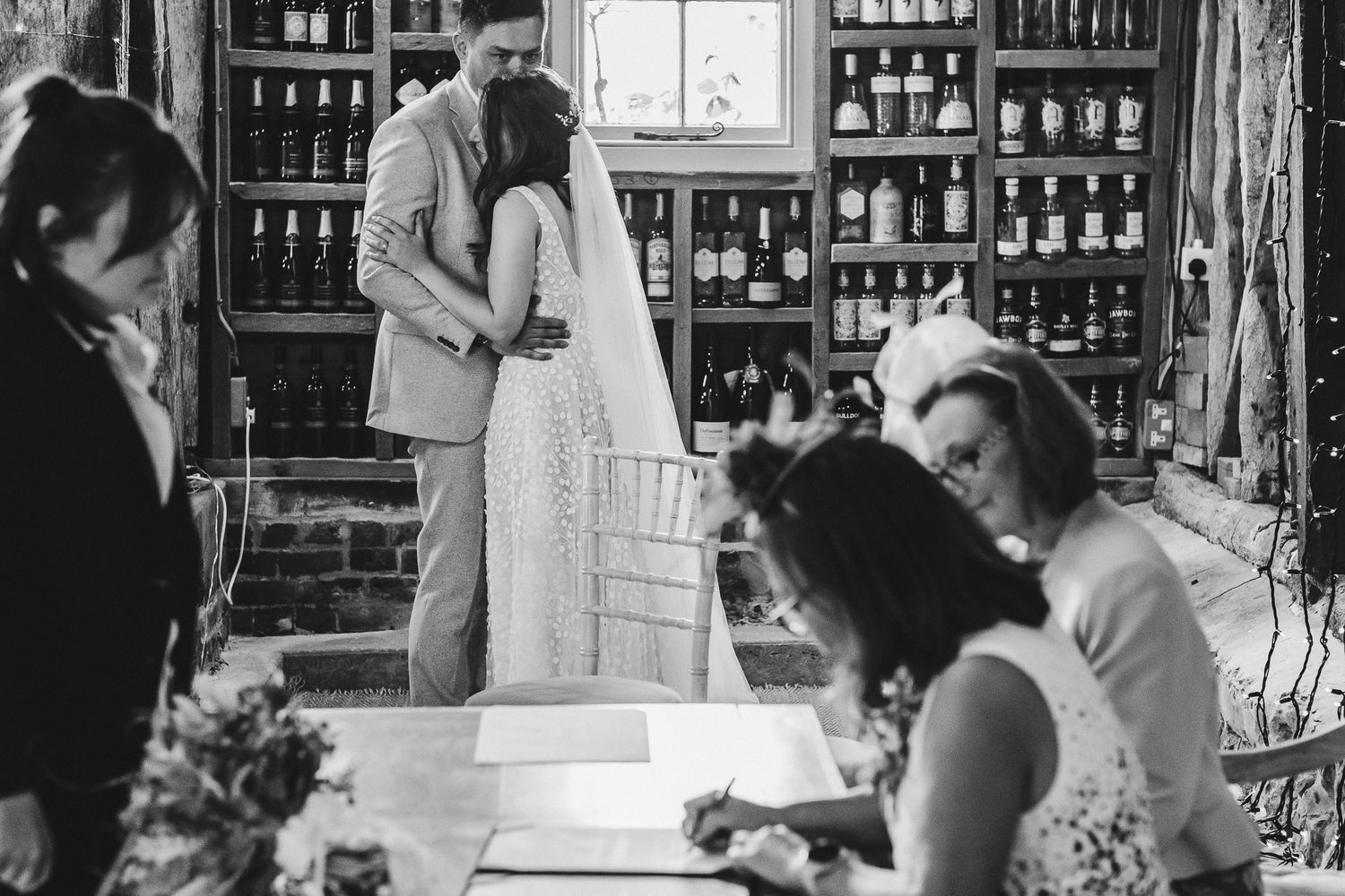 Intimate wedding ceremony moment captured in vintage wine cellar setting.
