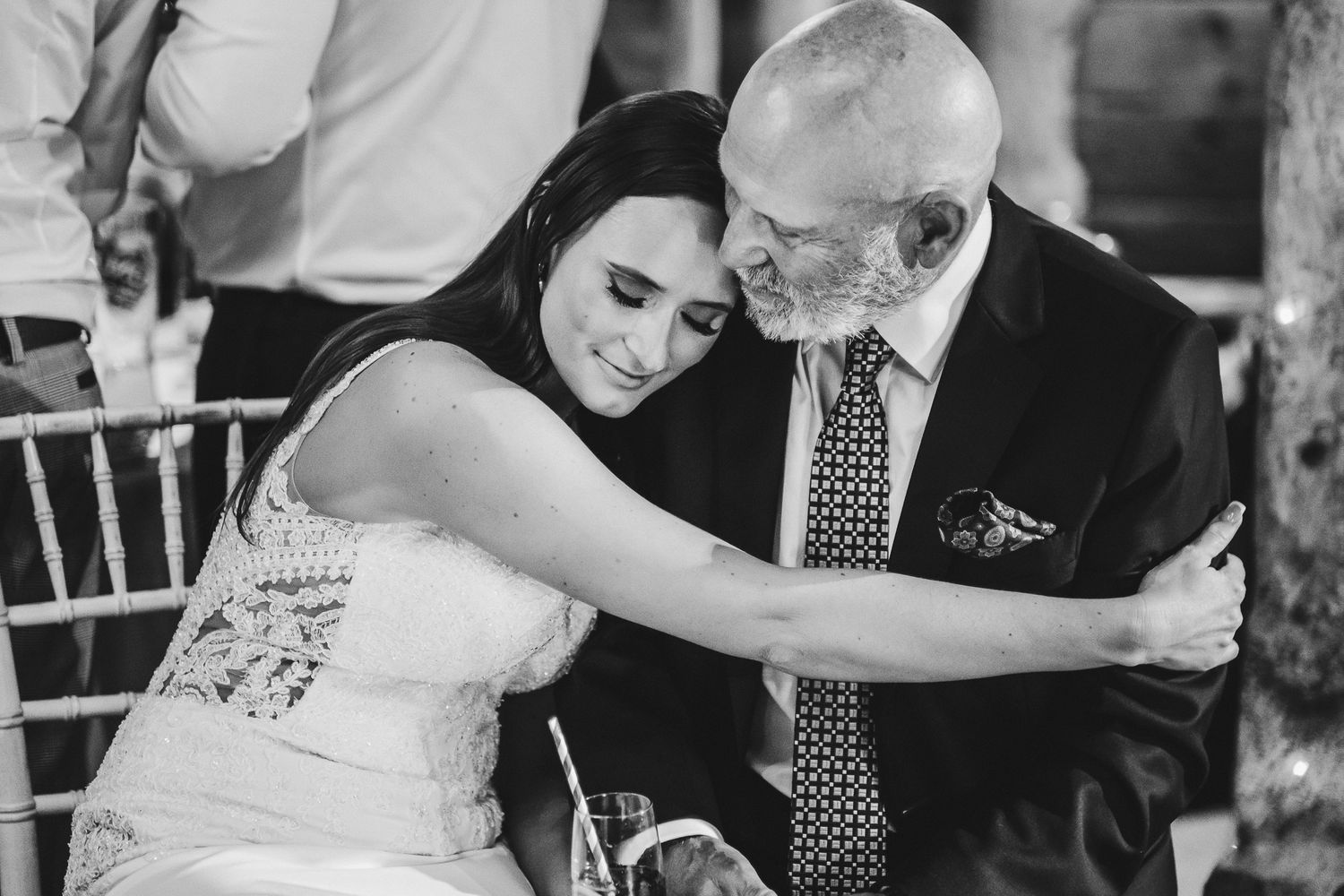 Touching black and white moment between bride and elderly guest at wedding reception.