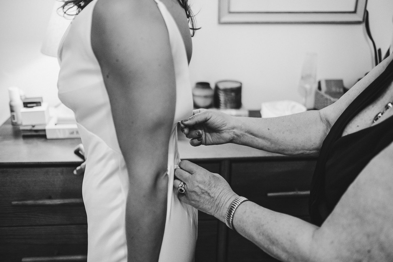 Candid moments captured during wedding preparations in a sunlit room.