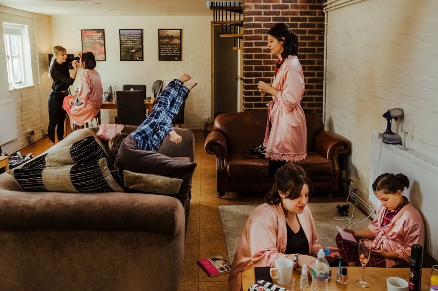 Wedding morning preparations in a cozy brick-walled room with natural lighting.