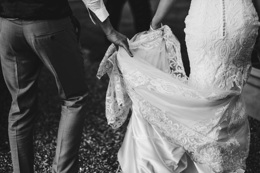 Wedding party walking together in formal attire during outdoor photo session.