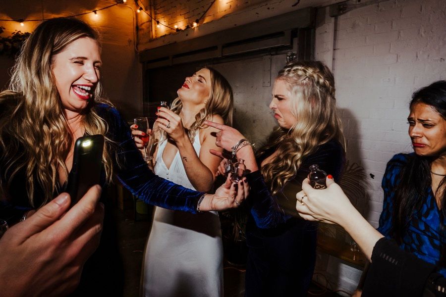 Guests share laughter and joy during evening wedding celebrations under warm lighting.