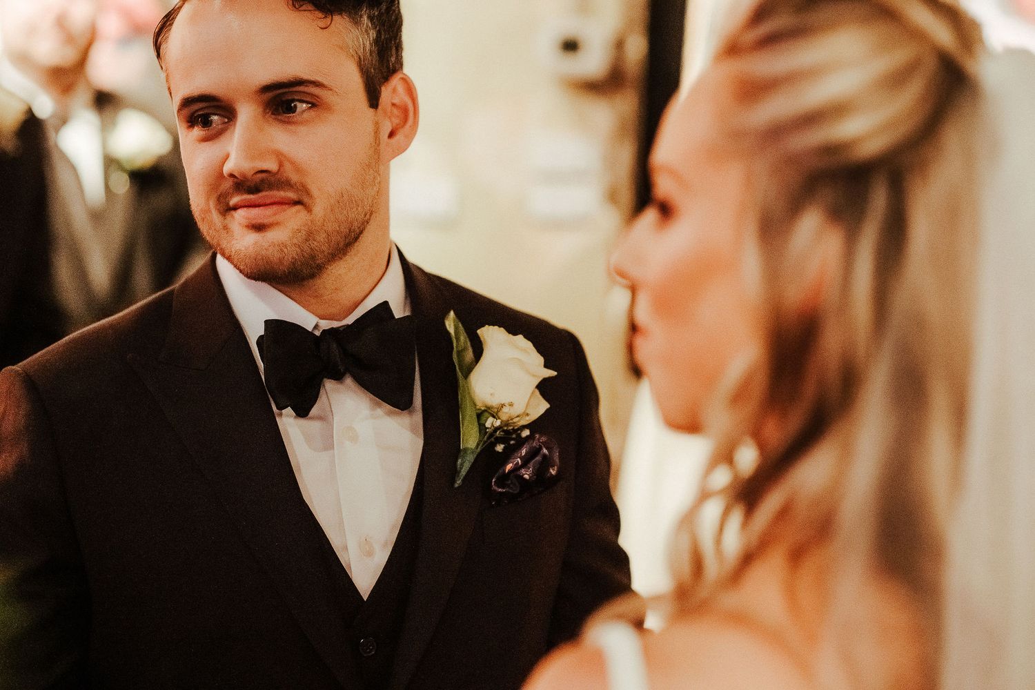 Couple shares intimate moment during wedding ceremony in elegant formal attire.