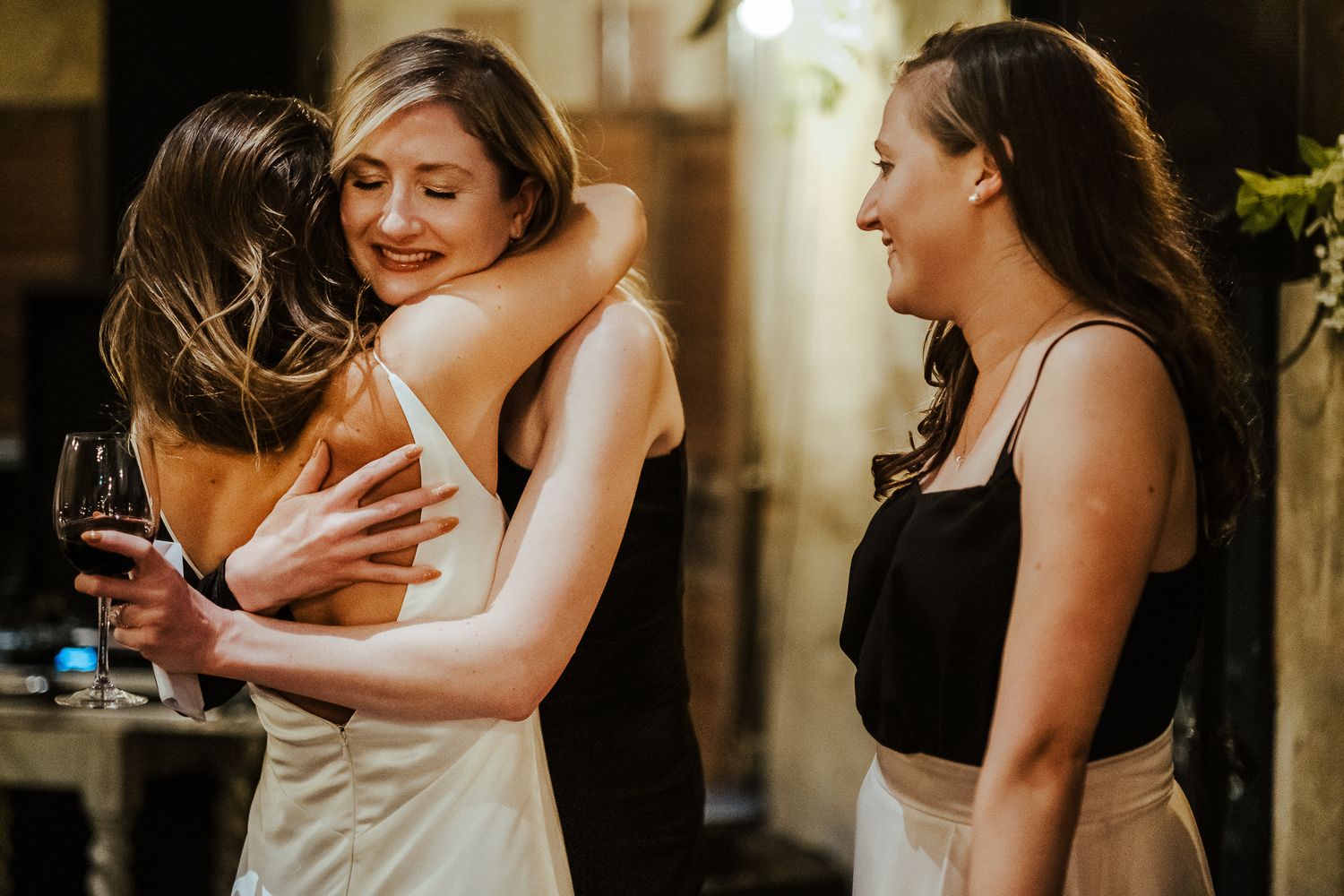 Friends share an emotional embrace while celebrating at an intimate party gathering.
