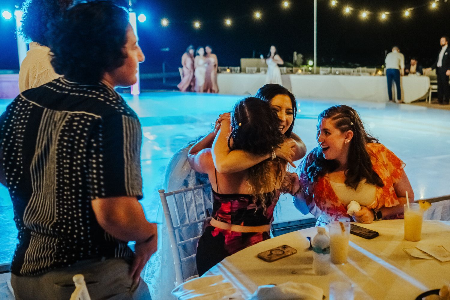 Guests enjoying drinks and conversation at an outdoor nighttime event.