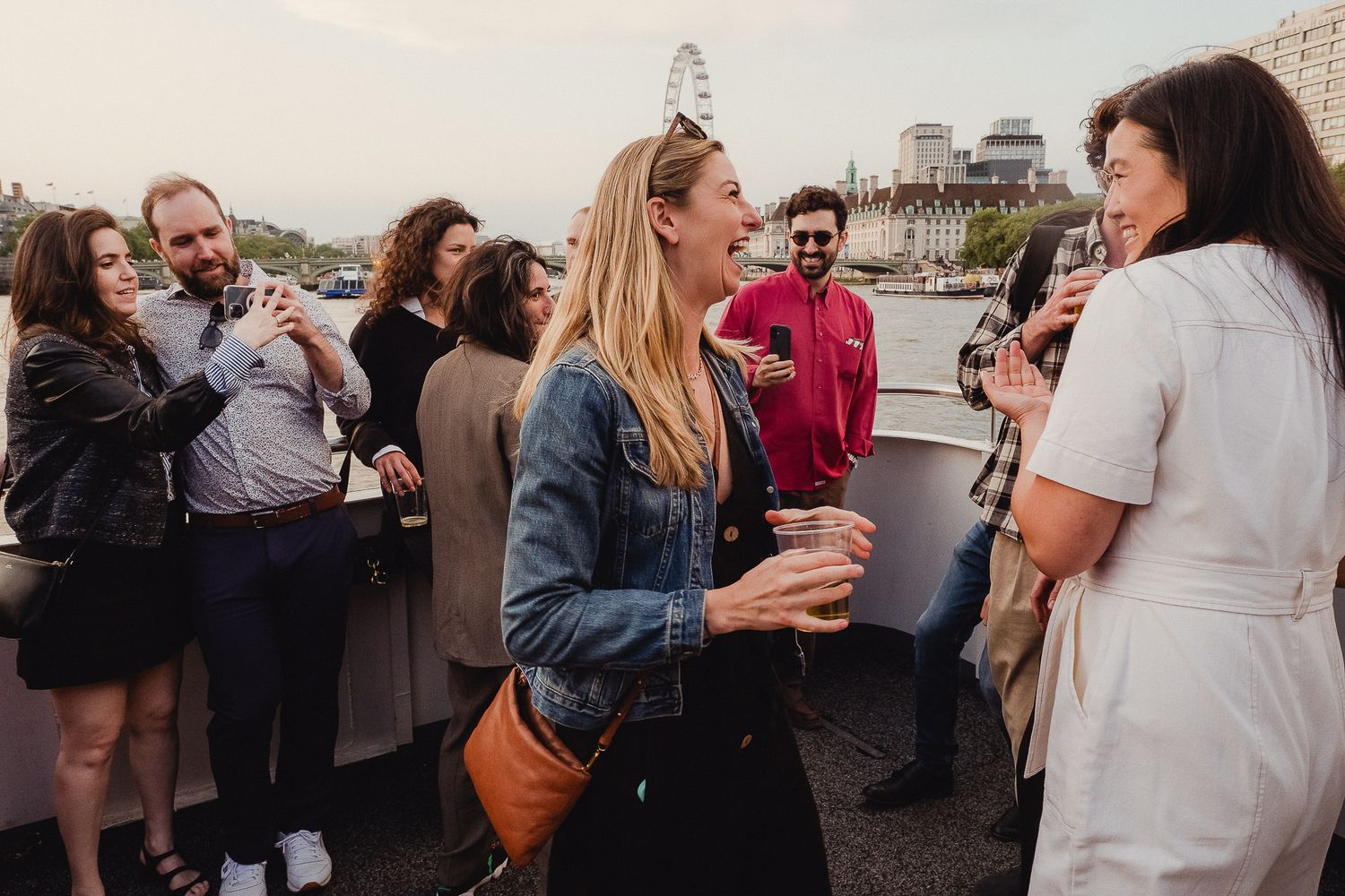 People enjoy drinks and socialize at an outdoor party on a sunny day.