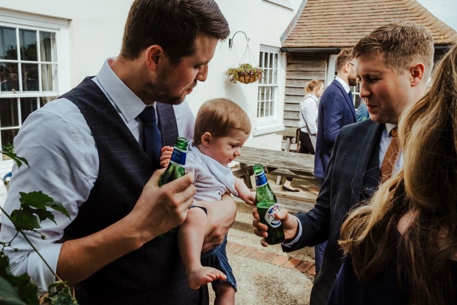 Guests socializing and enjoying drinks at an outdoor reception.