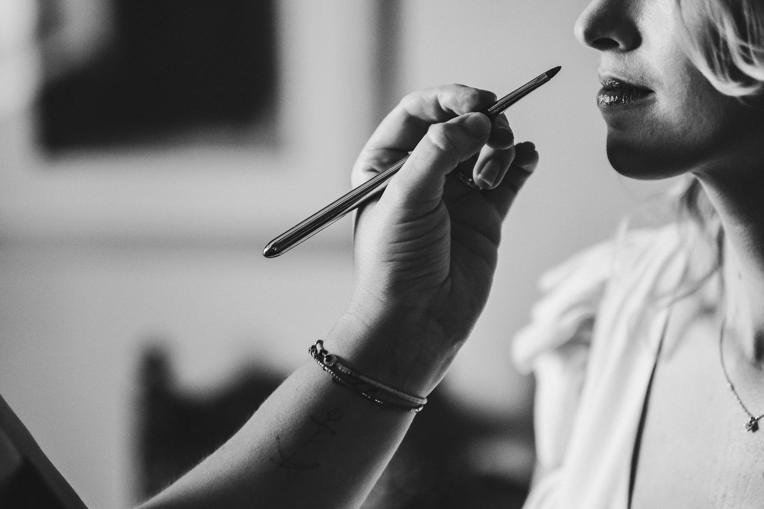 Close-up detail shots of makeup application during wedding preparations.