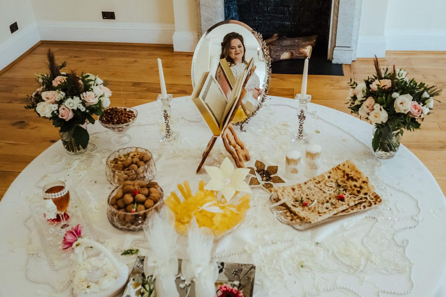 Elegant wedding reception table with floral centerpieces, candles and place settings.