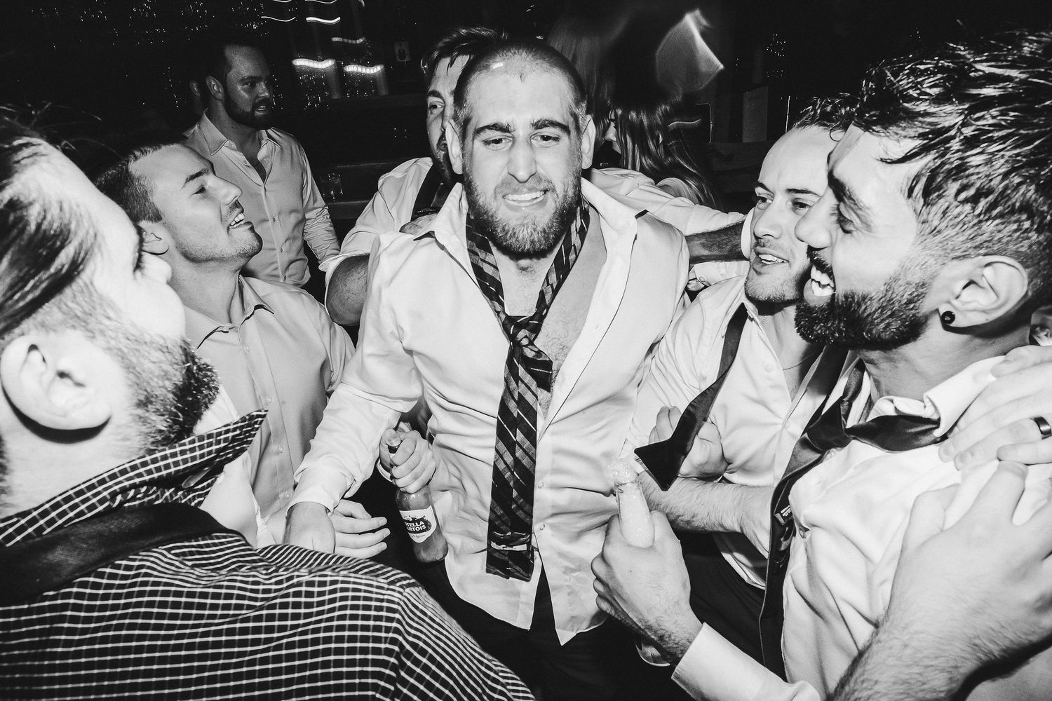 Group of wedding guests laughing and celebrating at reception party.