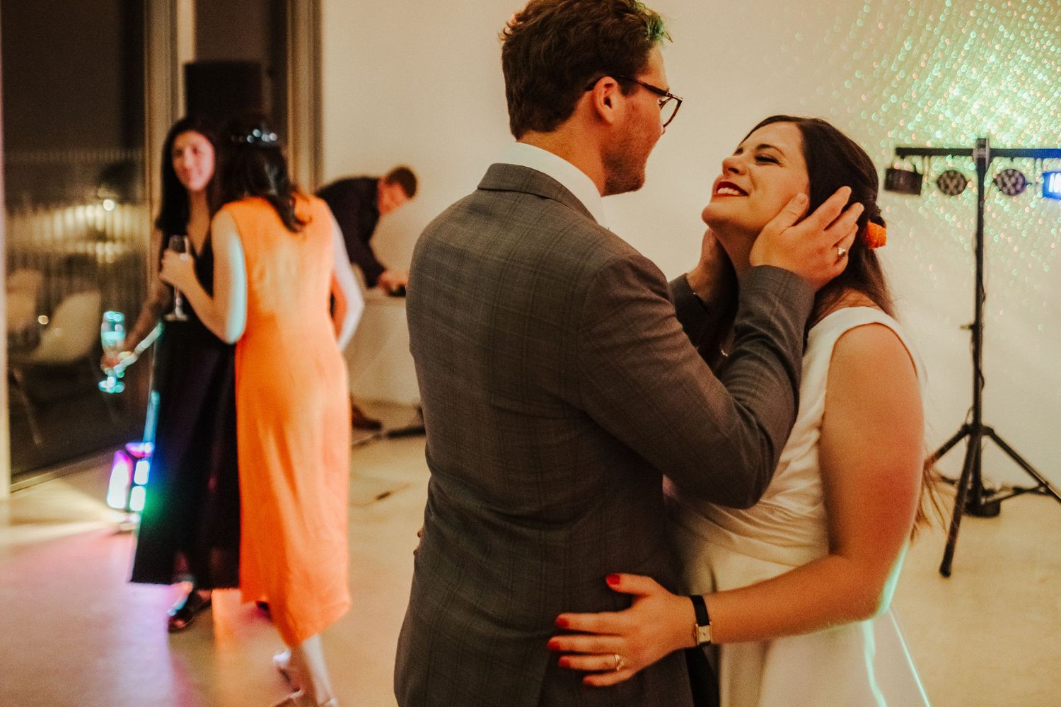 Intimate dance moment between couple at wedding reception with soft lighting.