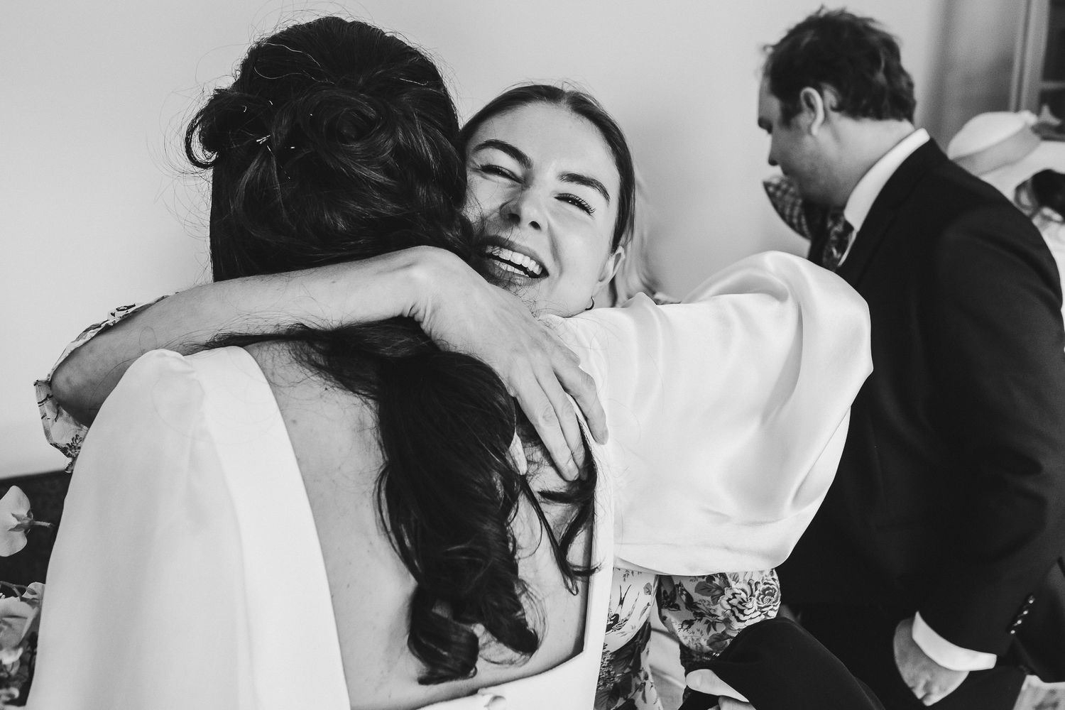 Black and white photo of emotional wedding celebration embrace.
