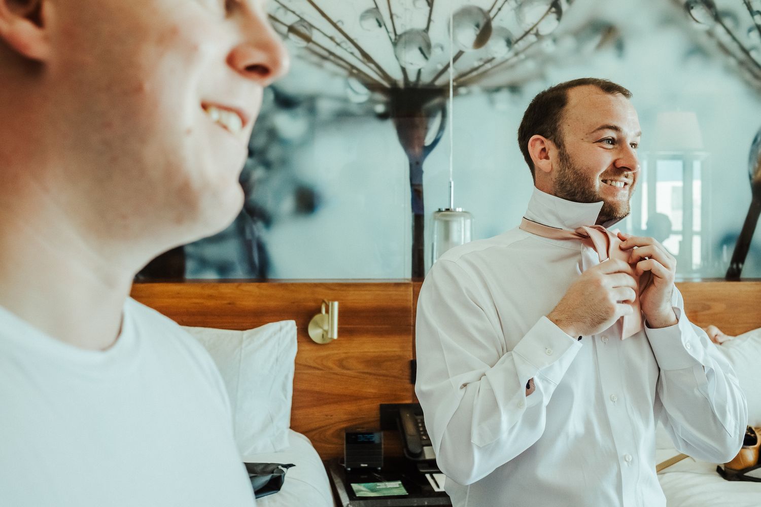 Two people adjusting their ties and getting ready for a formal event.
