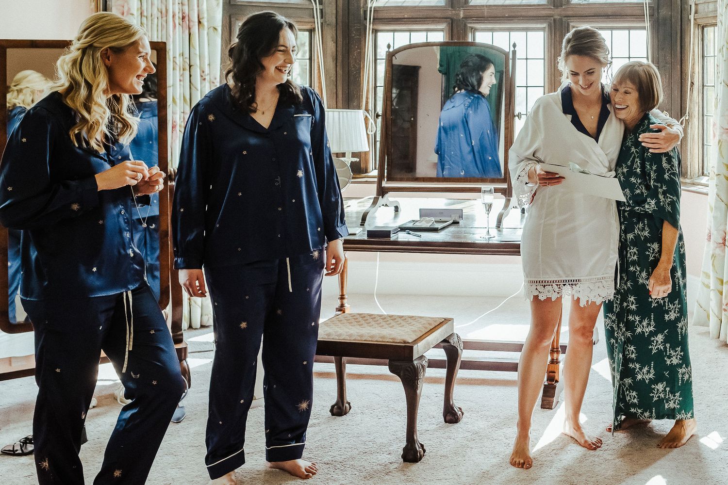 Group getting ready in a bridal suite with dress displayed in background.