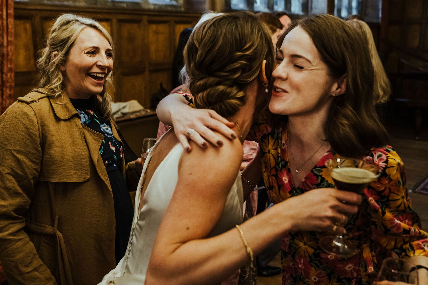 Natural light fills a reception space as guests share joyful conversations over drinks.