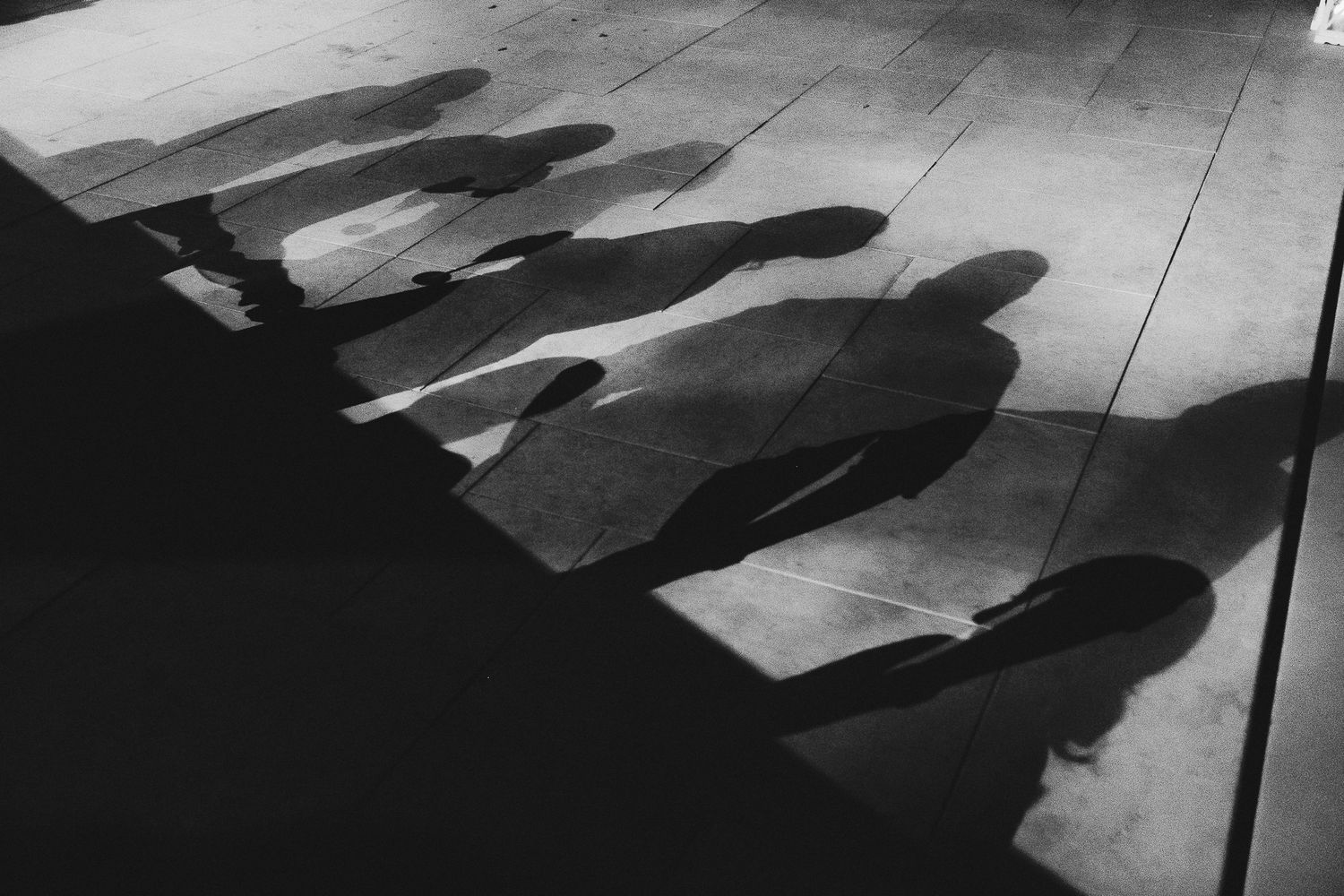Artistic black and white silhouette of dancing wedding guests on a dance floor.