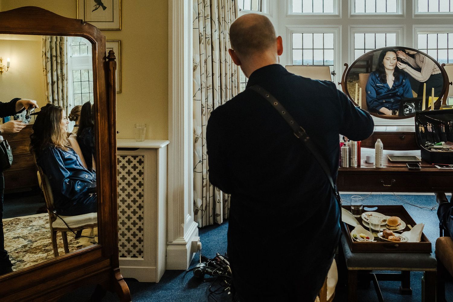Stylist working in an elegant room with large windows and mirrors.