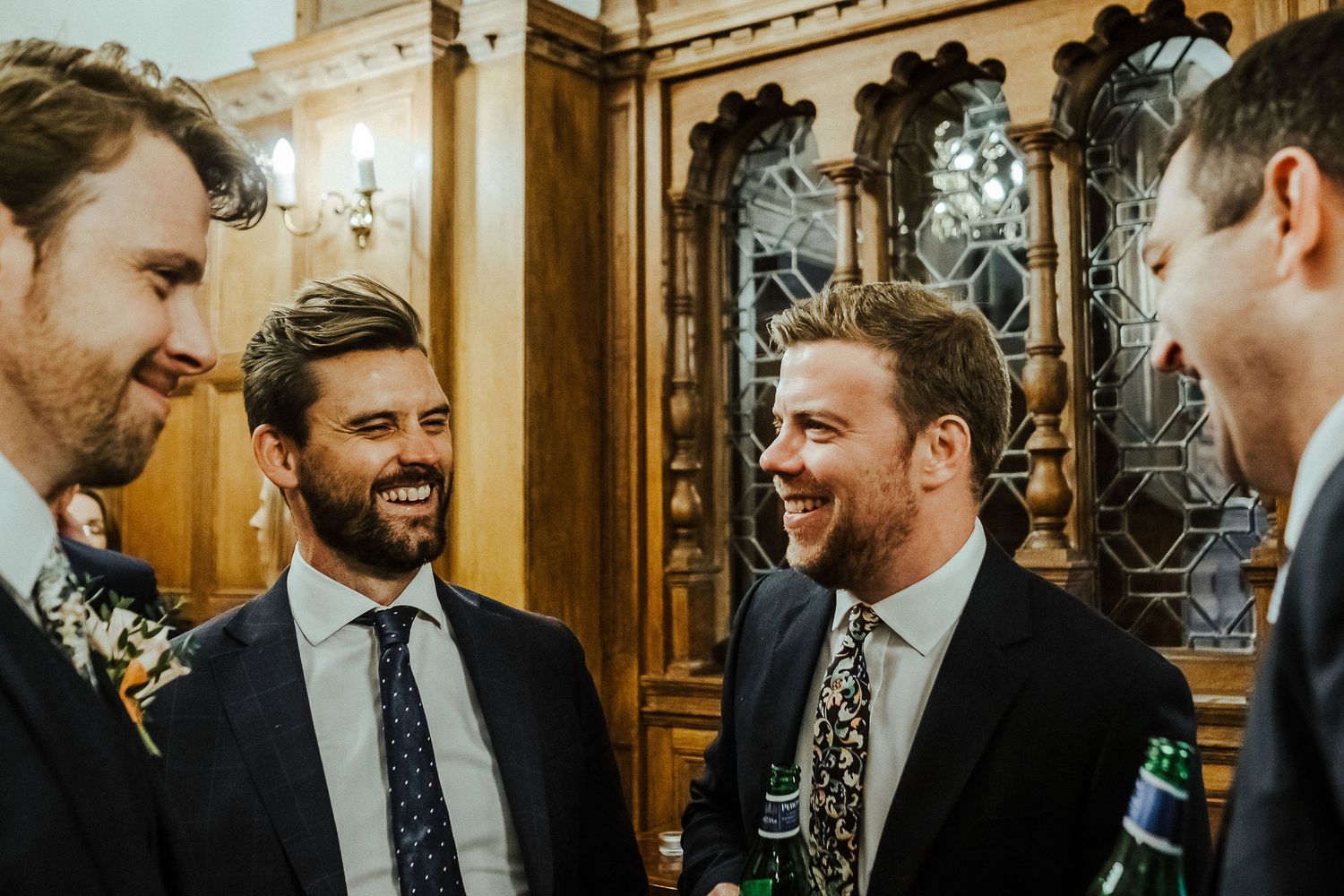 Elegant wood-paneled venue hosts wedding guests during evening celebration.