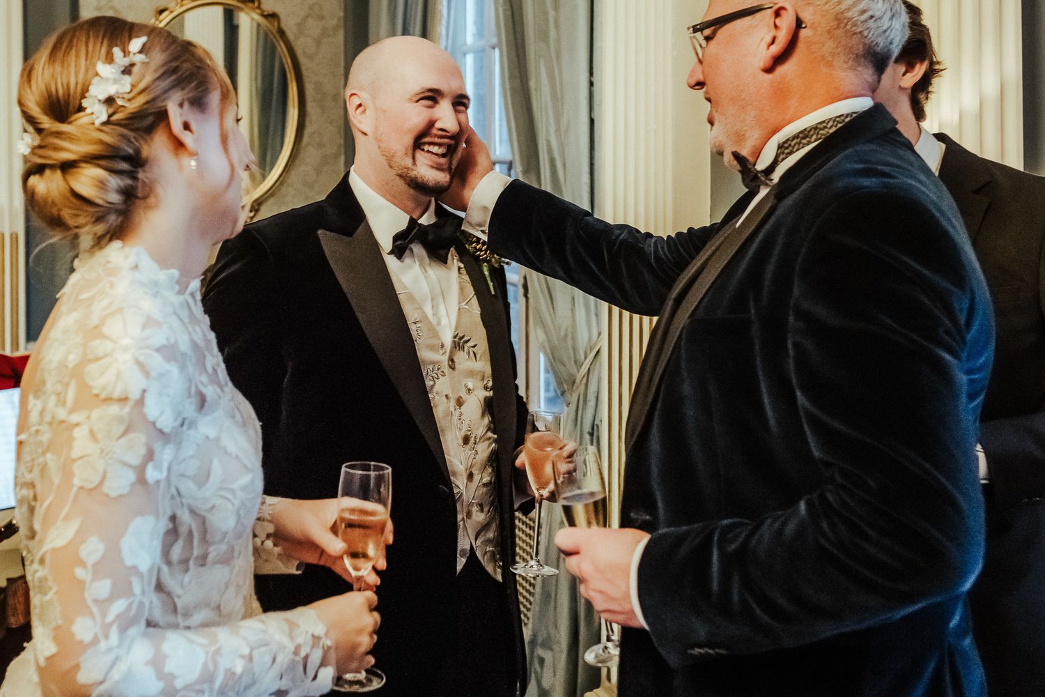 Wedding guests enjoying animated conversation during an elegant indoor celebration.
