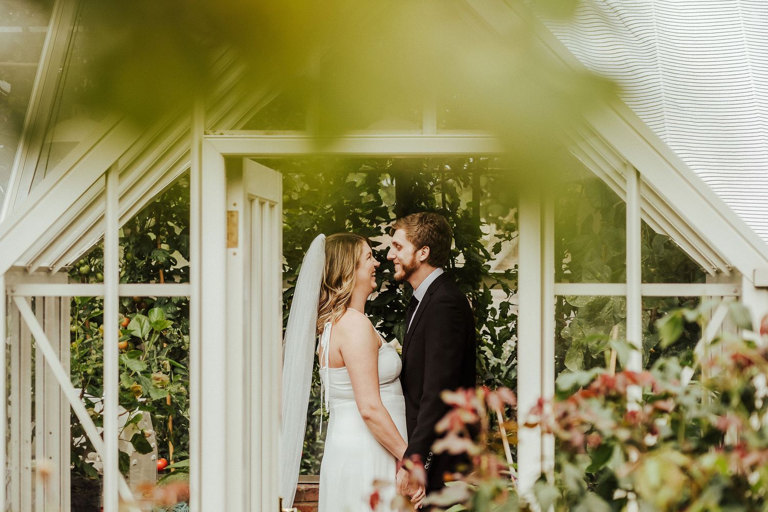 Romantic moment captured through window in a white garden gazebo.