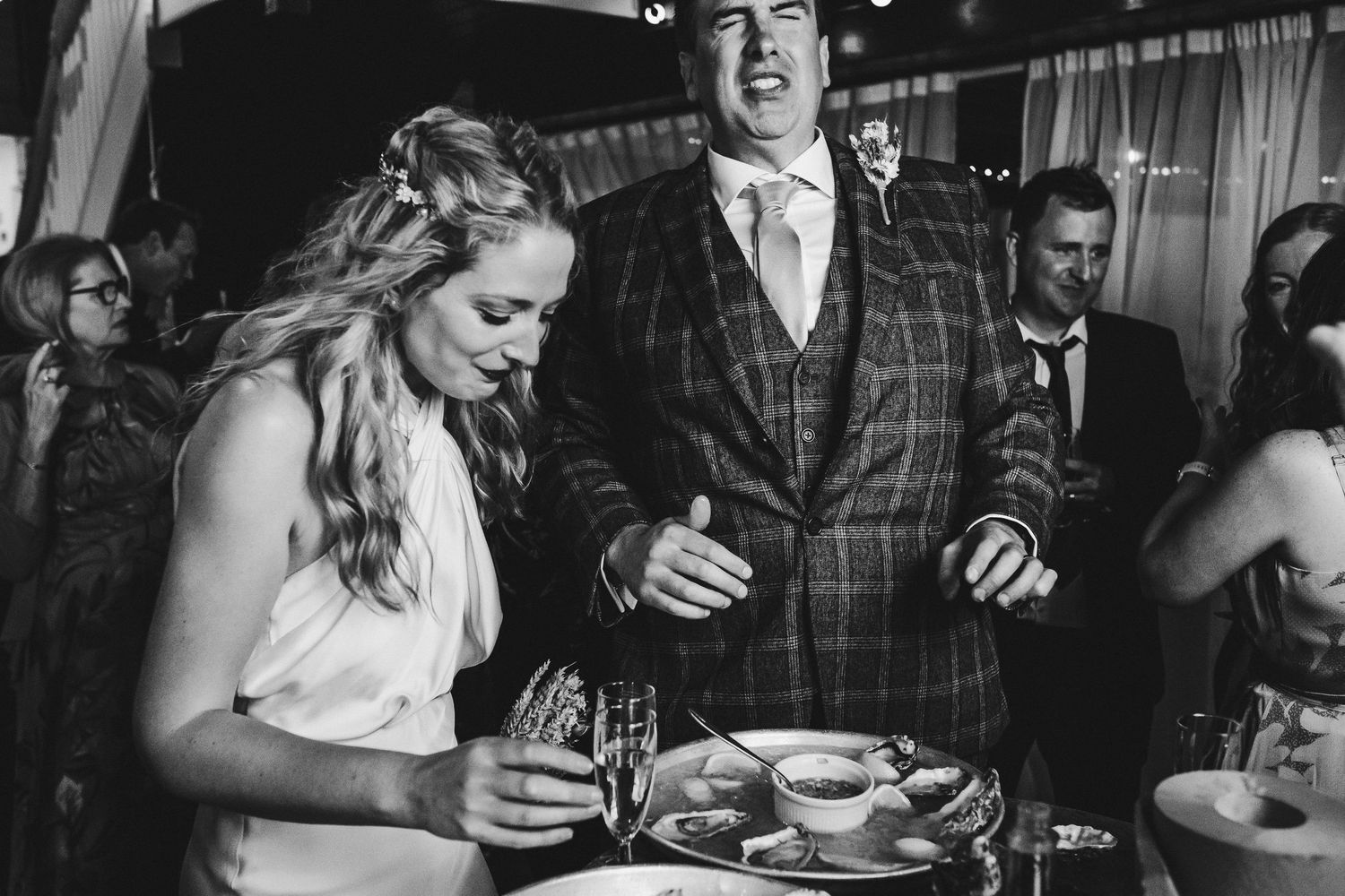 Wedding celebration sequence in black and white showing guests enjoying drinks and conversations.