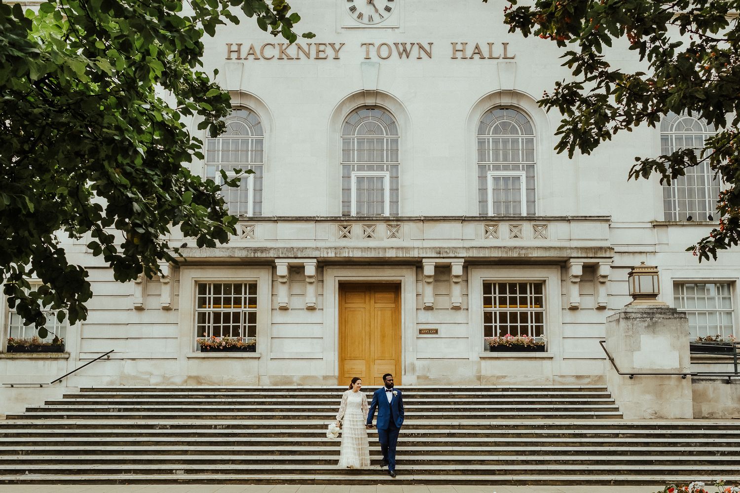 Classic white Hackney Town Hall building exterior with grand steps and architecture.