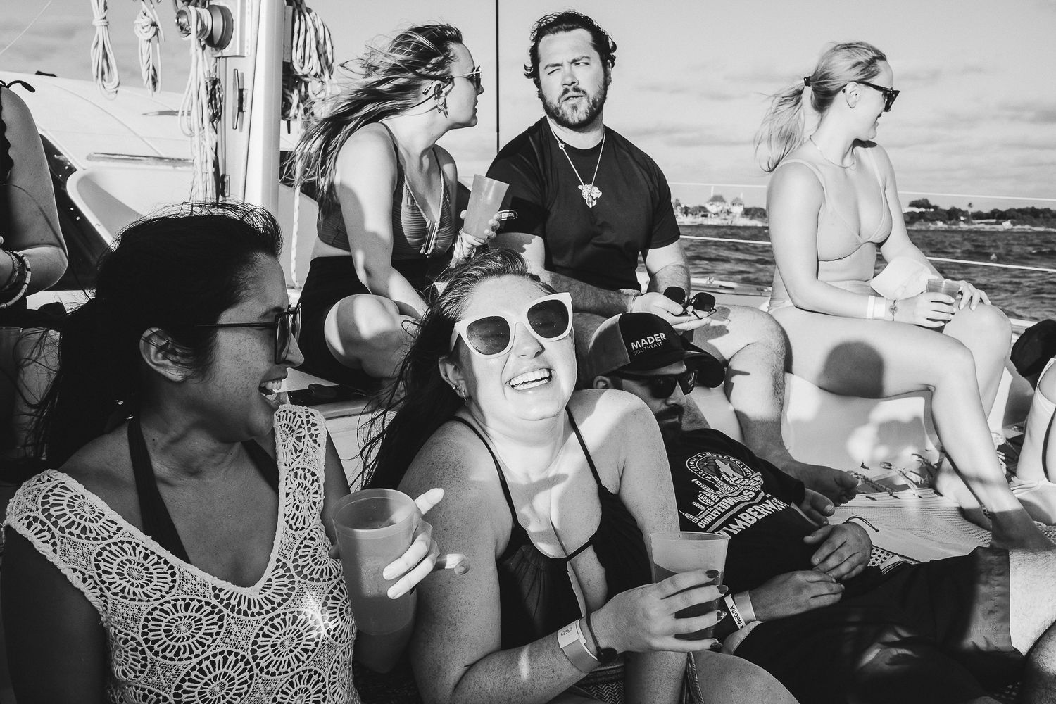 Friends enjoying a casual gathering on a boat deck in black and white photography.