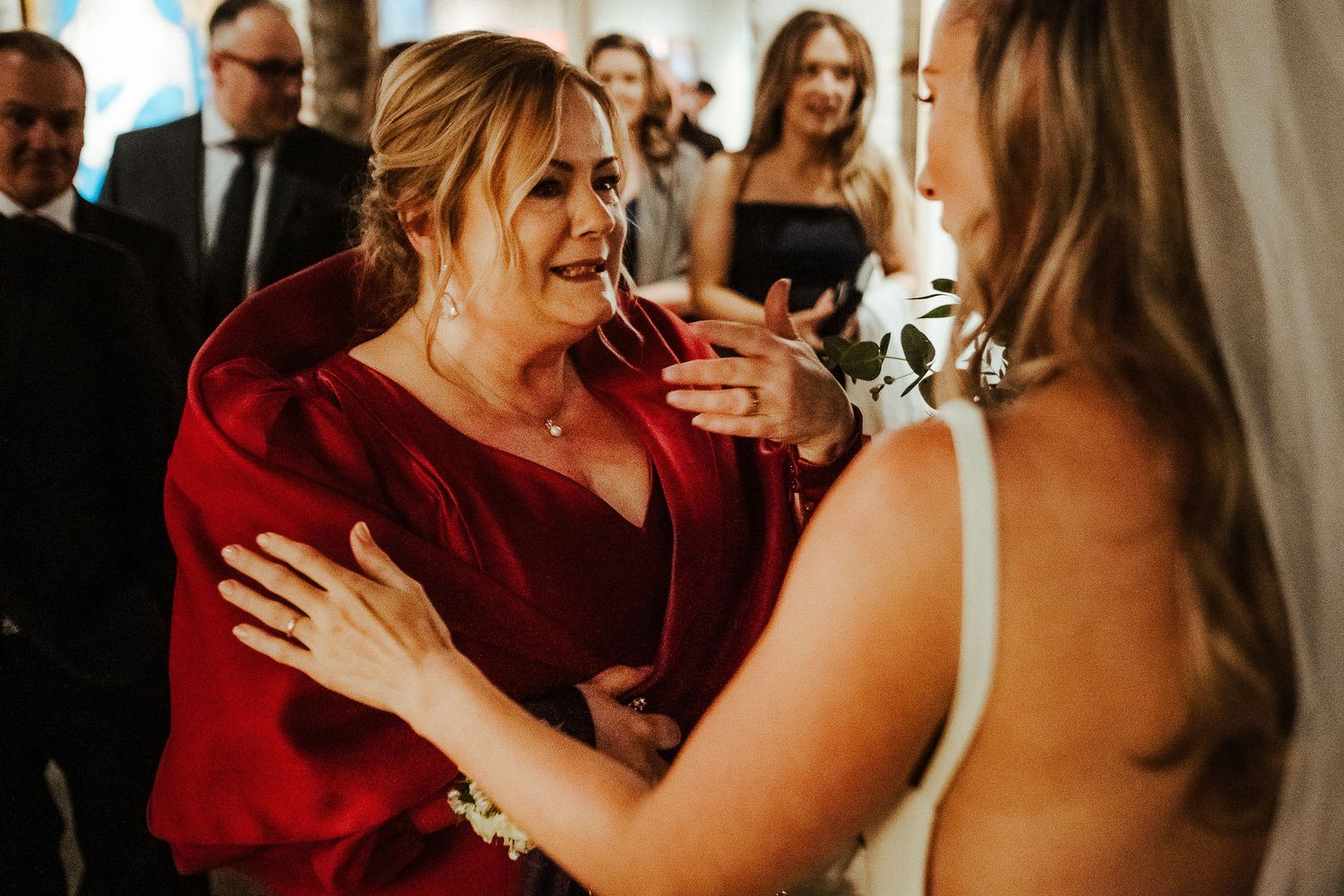 A guest in a red jacket shares an emotional moment during the wedding celebration.