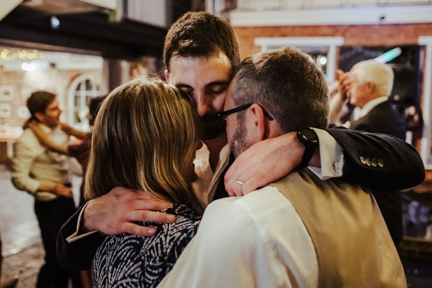An emotional group embrace shared between wedding guests during the celebration.