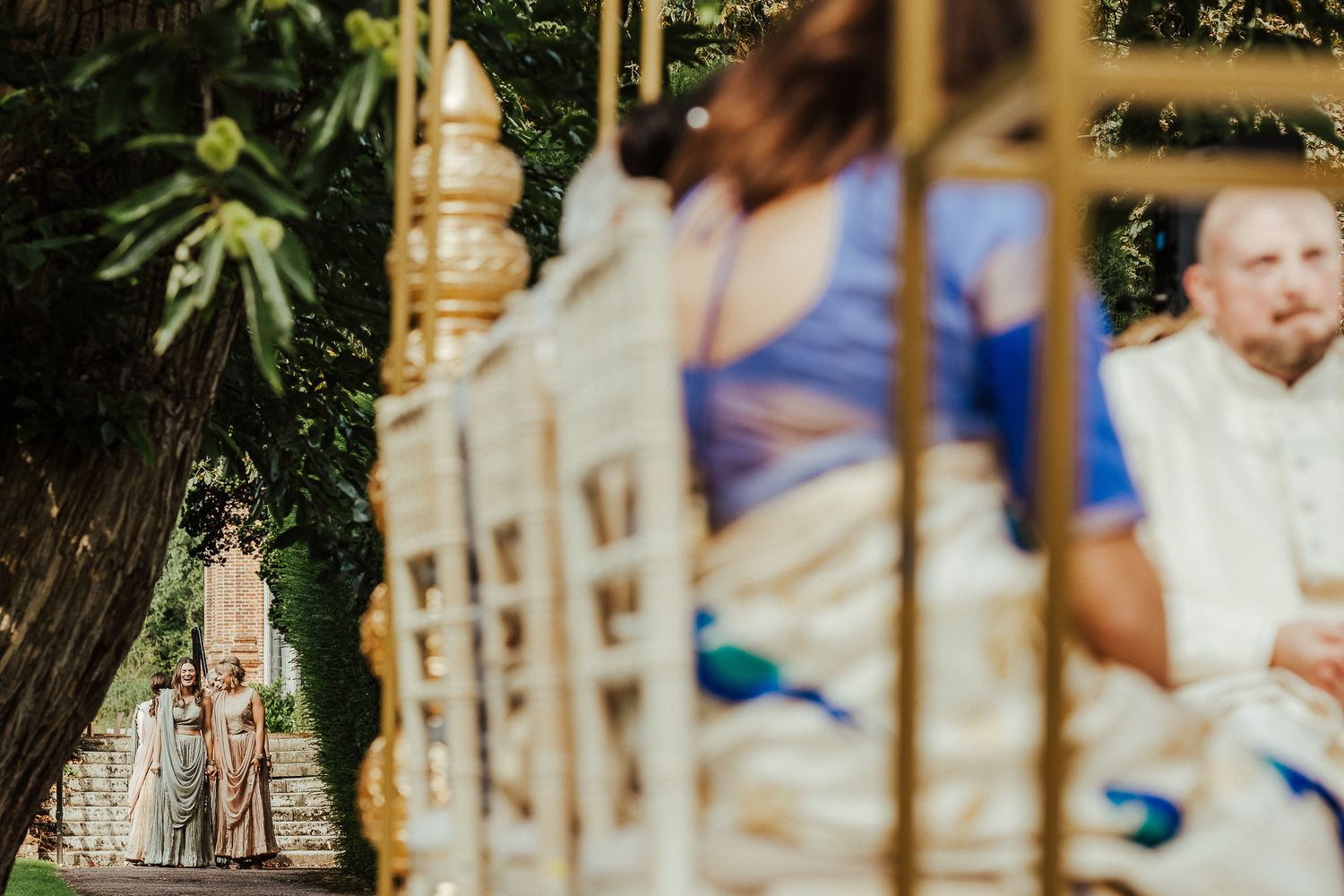 Artistic wedding photo shown through swing ropes with soft focus and dreamy bokeh effect in natural outdoor setting.