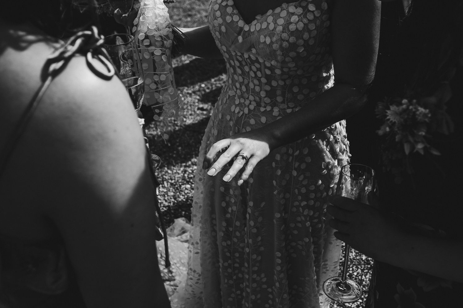 Black and white detail shot of elegant dress patterns at wedding celebration.