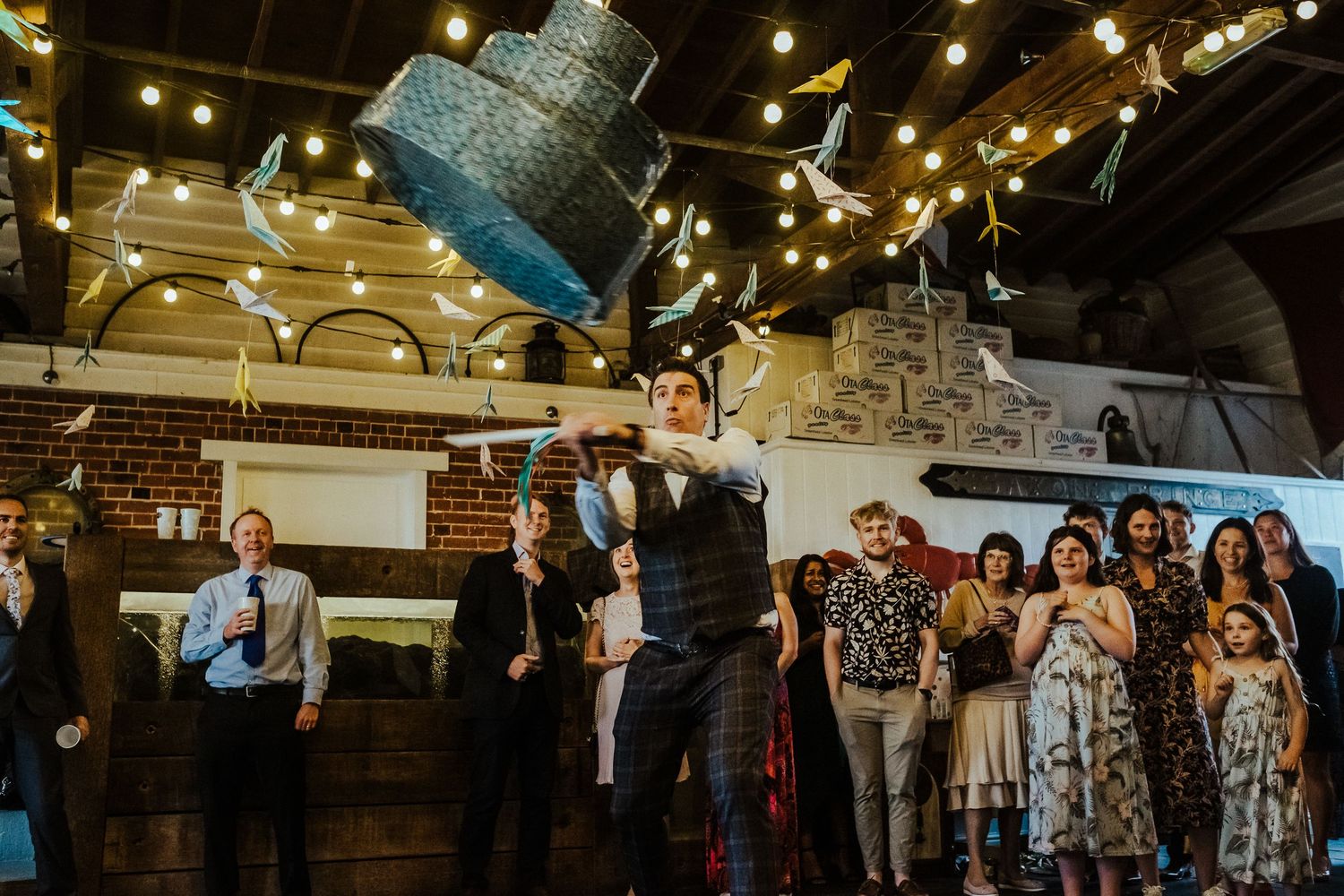 Wedding reception venue decorated with hanging string lights and rustic industrial elements.