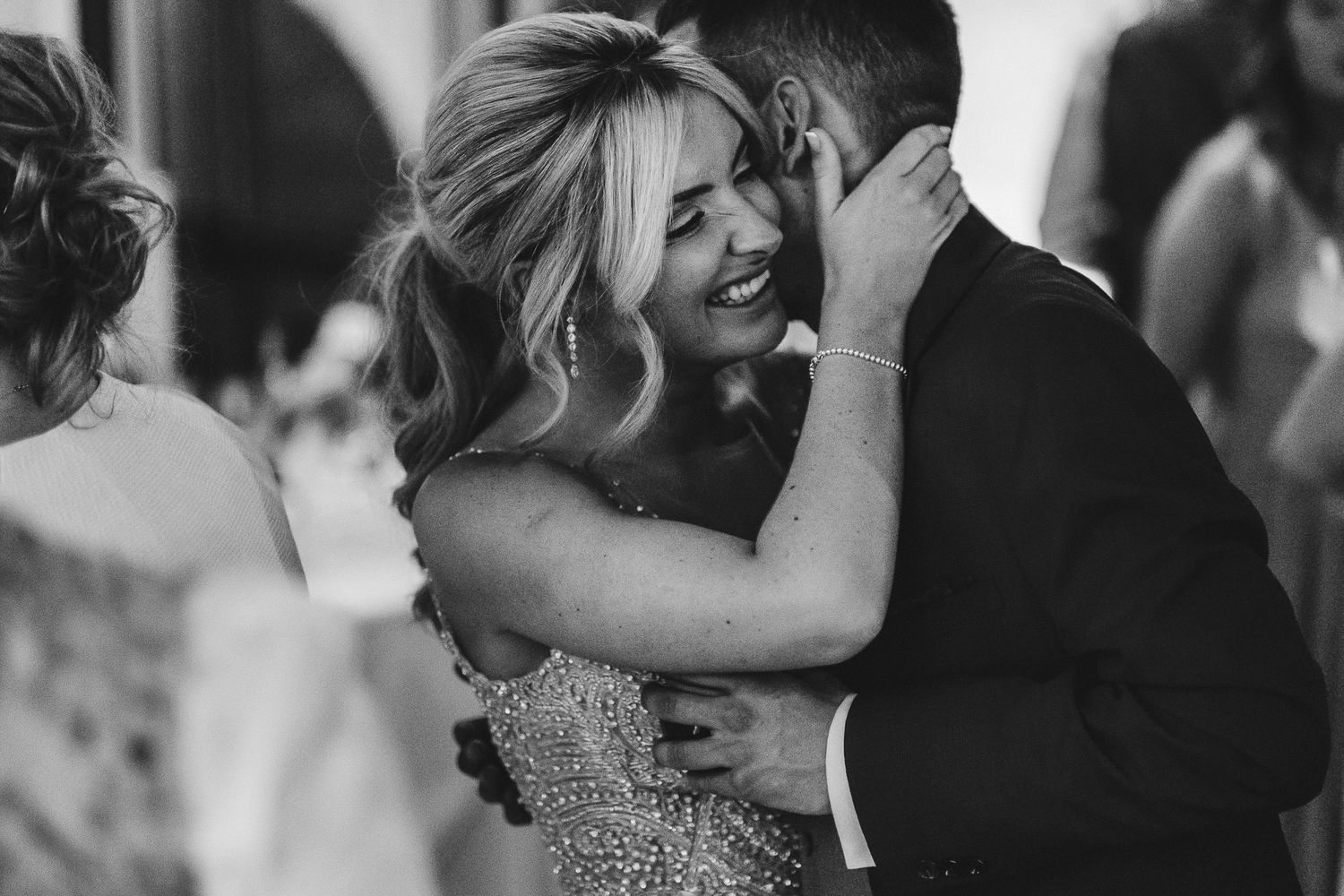 Black and white candid photograph captures an intimate dancing moment at a wedding reception.