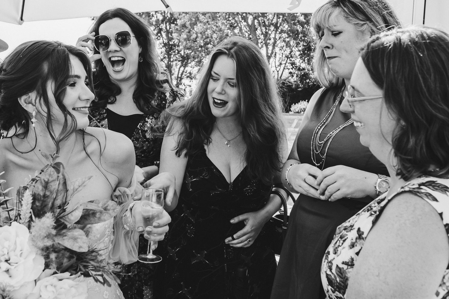 A group sharing laughs and drinks at an outdoor celebration.