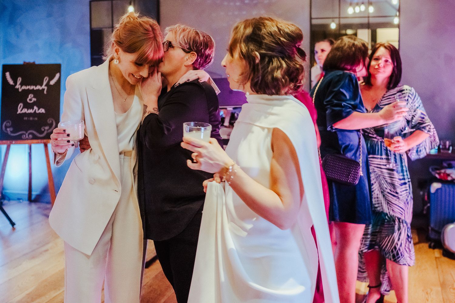 Guests enjoying a lively moment on the dance floor with vibrant party lighting.