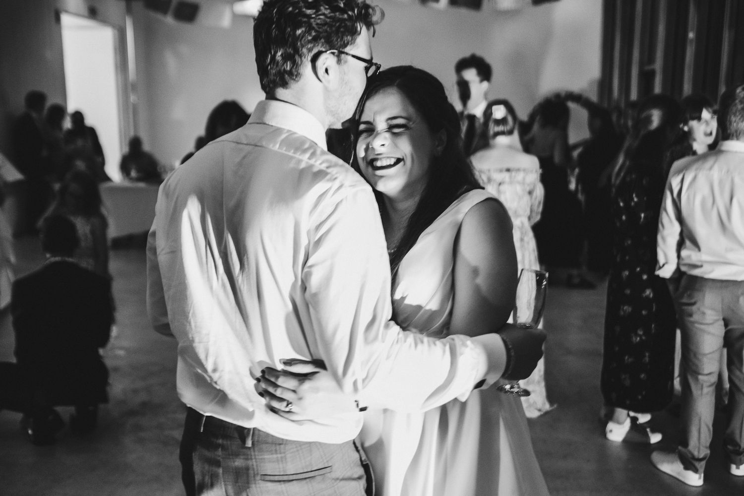 A couple shares a tender moment while slow dancing at their reception.