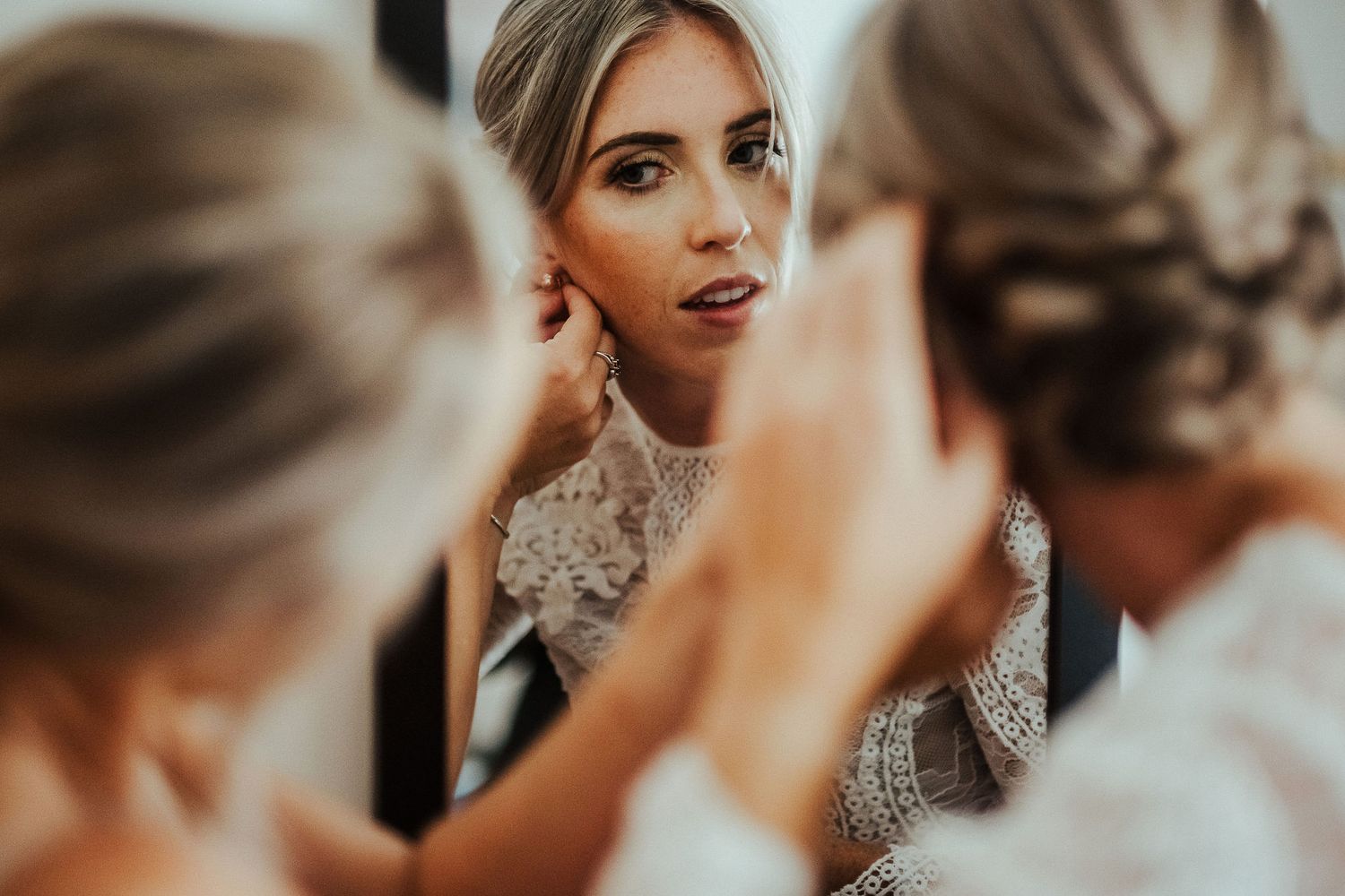 Intimate moments captured during bridal preparations with soft lighting and delicate lace details.