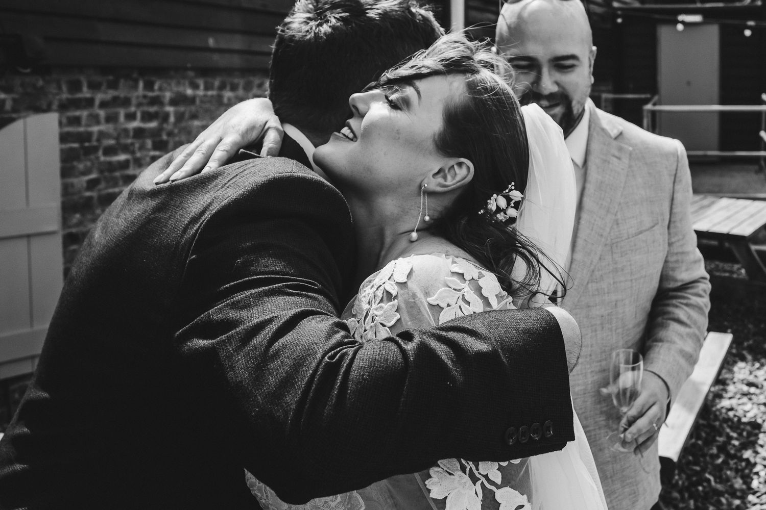Wedding guests celebrate and laugh together during outdoor reception.