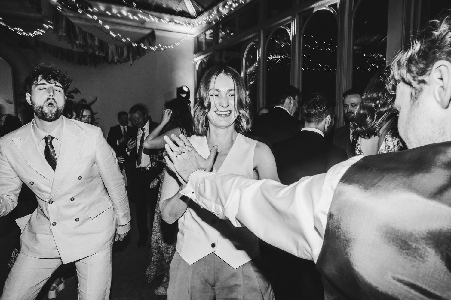 Black and white photo showing energetic dancing at a vintage-style celebration.